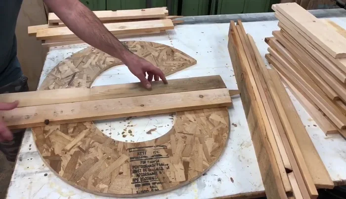 Trace and cut slats: Flip the letter upside down. Place the letter back on top of the boards and trace around it. Trim the excess wood from the boards using a miter saw.