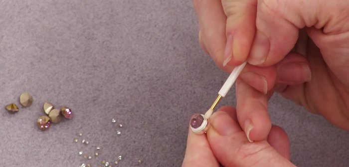 Carefully place the smaller lens sew-ons around the central pointed sew-on, ensuring each is firmly embedded and slightly spaced apart.