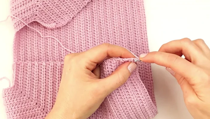 Create border: Chain 1, single crochet (sc) along the side of the last row up to the neckline. Chain 3, turn, skip 2 stitches, sc in the next, *make a buttonhole (sc in next 6 stitches, ch 2, skip 2 stitches, sc in next stitch)*, repeat from * to * until all buttonholes are made.