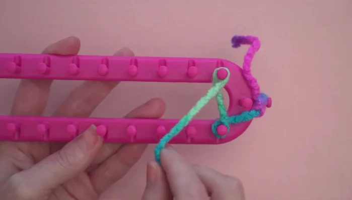 Pushing the loops down to the base of the pegs and working back, adding a second loop to each peg (except the last one).