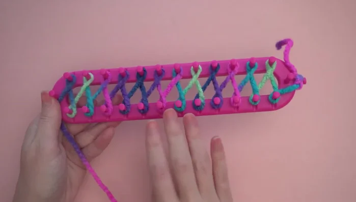 Pushing the loops down to the base of the pegs and working back, adding a second loop to each peg (except the last one).