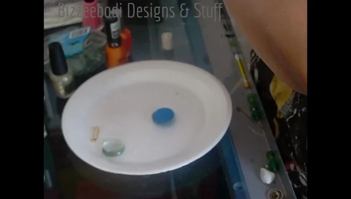 Once the polish is completely dry, apply a small amount of adhesive to the back of the glass gem.