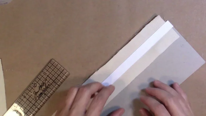 Fold the overhanging fabric over the chipboard and secure with a scrap piece of chipboard to hold it in place.