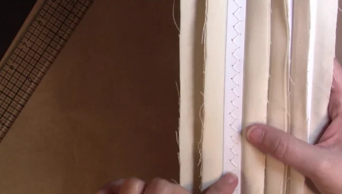 Stitch the pages to the chipboard spine to secure them.