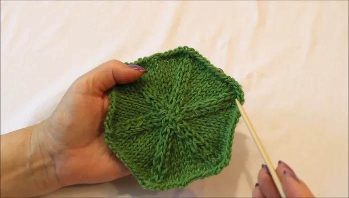 Continue decreasing and knitting plain rows until you reach the center. Adjust stitch placement as needed to maintain even tension and prevent stitches from spanning multiple needles.