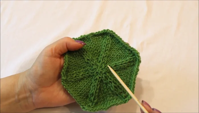 Continue decreasing and knitting plain rows until you reach the center. Adjust stitch placement as needed to maintain even tension and prevent stitches from spanning multiple needles.