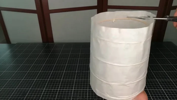 Apply diluted wood glue to the edges and carefully press the paper back onto the structure on both ends.