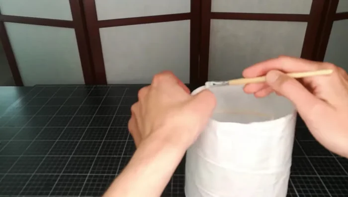 Apply diluted wood glue to the edges and carefully press the paper back onto the structure on both ends.