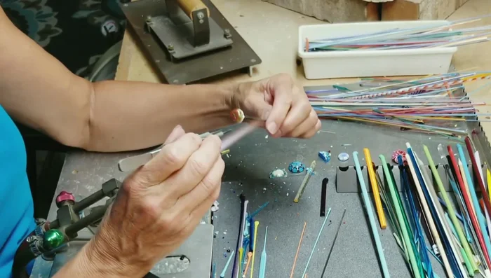 Using graphite tweezers, shape and refine the flower design, removing excess glass.