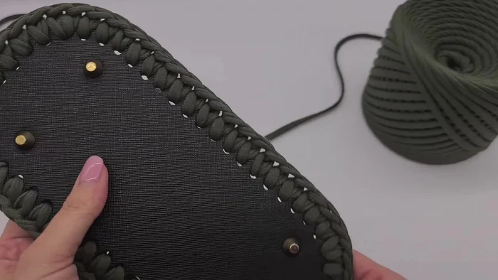 Finish the row, cut the yarn, and weave it through below the first single crochet of the row, pulling it through and bringing it back to the middle of the last stitch.