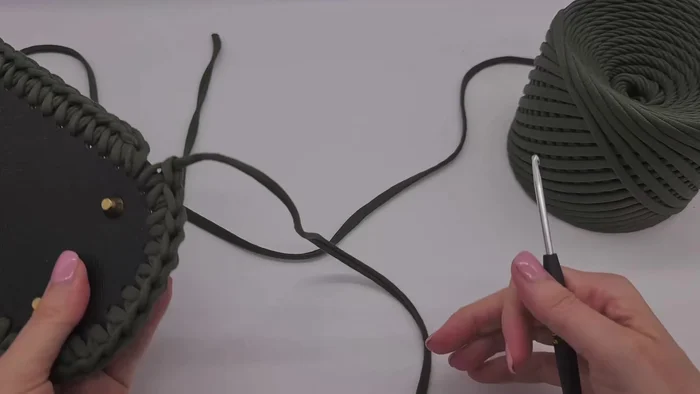 Finish the row, cut the yarn, and weave it through below the first single crochet of the row, pulling it through and bringing it back to the middle of the last stitch.