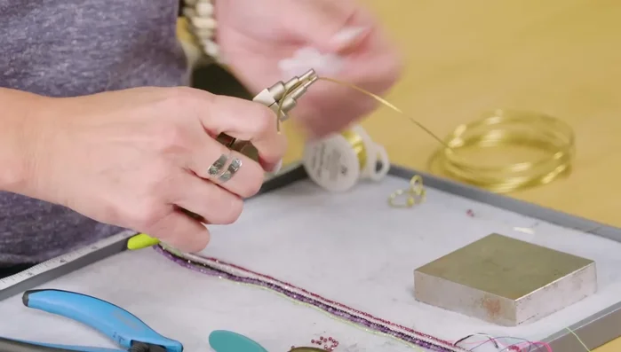 Gently shape the wire into a heart shape using your hands, curving the wire downwards on each side of the loop.