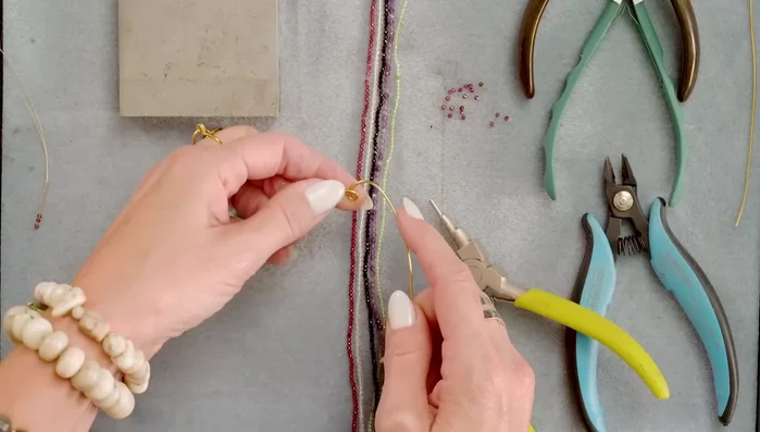 Gently shape the wire into a heart shape using your hands, curving the wire downwards on each side of the loop.