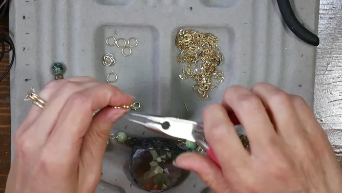 Attach the necklace chain: Use jump rings to attach a multi-strand chain with a lobster claw clasp.