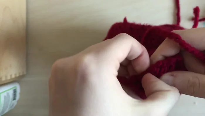 Attach the large pom-pom to the top of the hat, tying securely and weaving in loose ends.