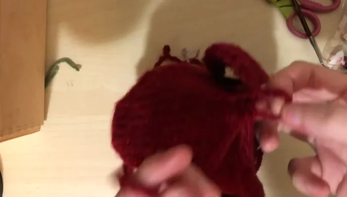 Attach the large pom-pom to the top of the hat, tying securely and weaving in loose ends.