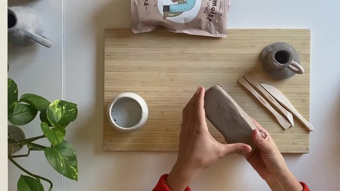Flatten the clay ball into a smooth slab, about a quarter of an inch thick (3/4 cm). You can use a rolling pin, glass jar, or your hands.