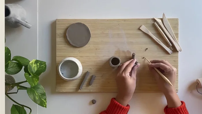 Reinforce the handle by wrapping a small coil around it, and blend into the main piece.