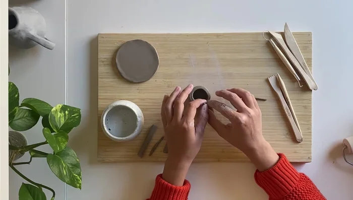 Reinforce the handle by wrapping a small coil around it, and blend into the main piece.