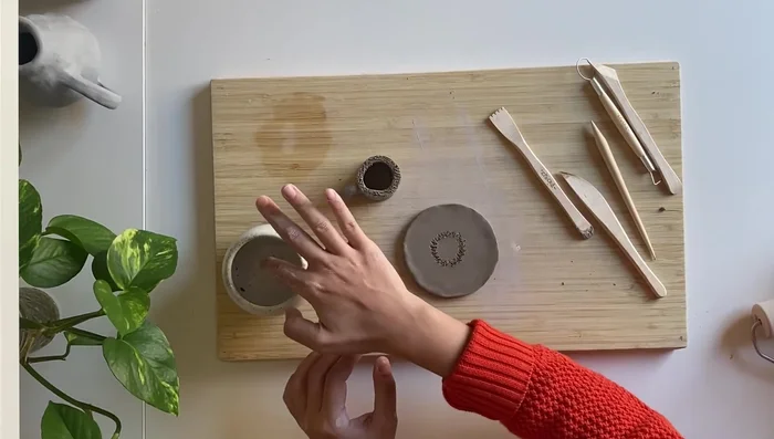 Attach the candle holder to the base. Score both the base and the candle holder, apply water, and attach. Blend the seam with another small coil.