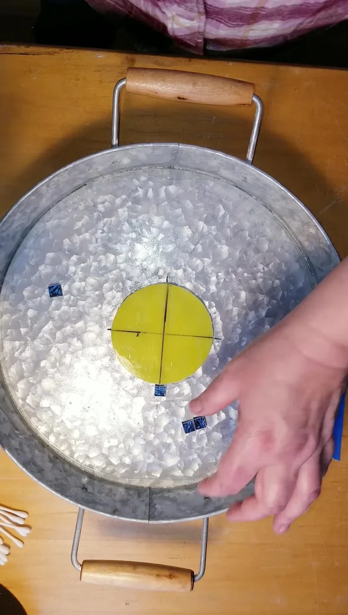 Carefully place the smaller glass pieces around the central circle, ensuring even spacing and using tweezers if needed.