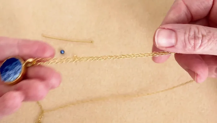 Slide one end of the chain through a bezel setting or other desired pendant.