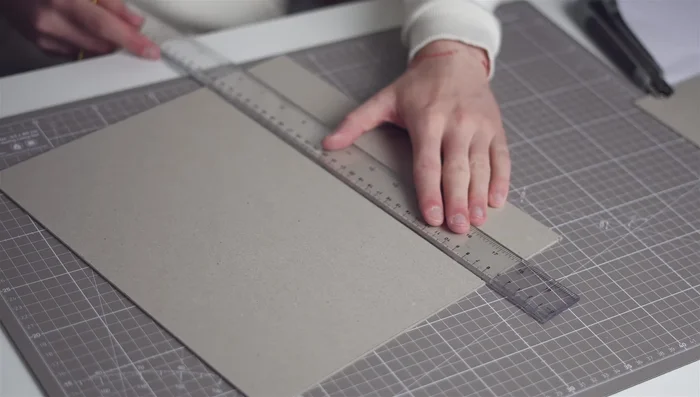 Cover Preparation: Cut and prepare boards for cover. Prepare book cloth with heat-transferred artwork. Attach boards to linen using double-sided tape and glue for edges.