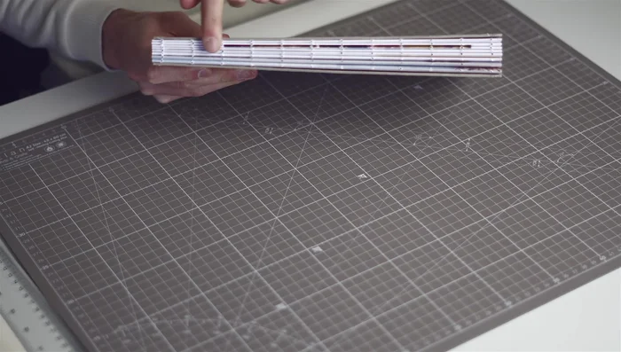 Stitching: Stitch signatures together using bookbinder's thread and a needle, keeping tension consistent. Secure knots at the beginning and end.