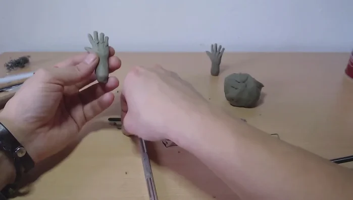 Add knuckles: Add small balls of clay to represent the knuckles, then carefully blend them into the hand.