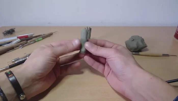 Form the palm and thumb area: Pinch and shape the clay to create a distinct palm area and a slightly separated area for the thumb.