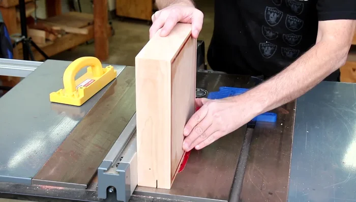 Separate the lid from the box using a table saw and shims to prevent blade pinching.