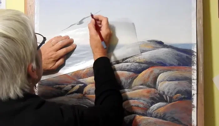 Adding details to the seagull using a pastel pencil for finer lines.