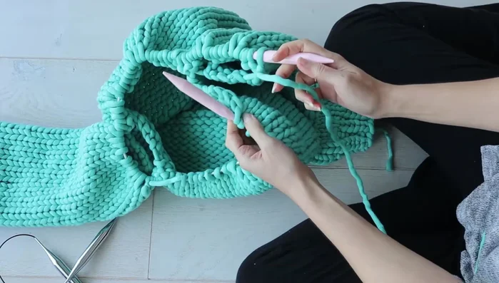 Now all sleeve and body stitches are on one circular needle. Continue knitting in the round.