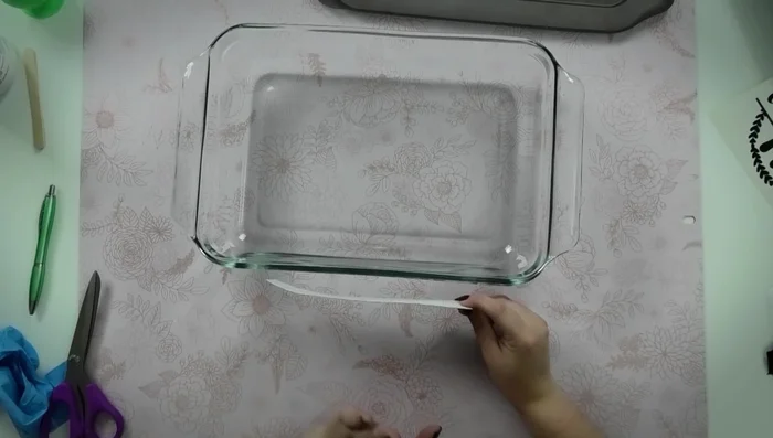 Use the hinge method to apply the stencil to the side of the casserole dish. Secure with painter's tape to ensure straight application.