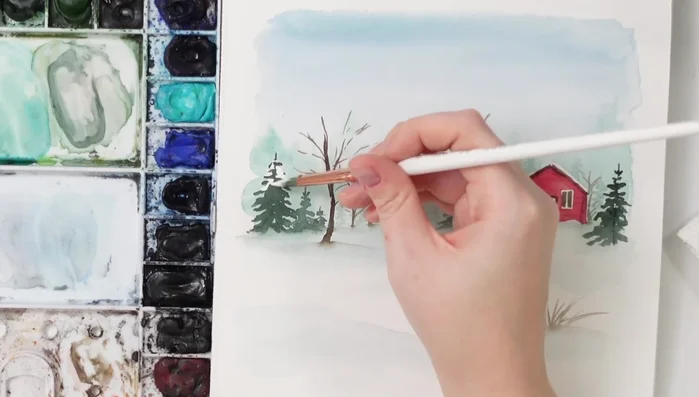 Add snow to the trees using white ink or gouache, applying it in various ways to simulate snow collecting on branches and a light snowfall.