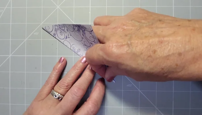 Bring the bottom triangle towards you, aligning the edges and reinforcing the crease.