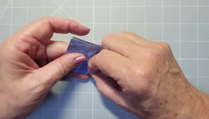 Pinch and fold the closed side over to the center line, creating a crease.