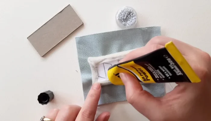 Cut 1cm strip of lightweight card, cover in fabric, and glue around cushion edges.