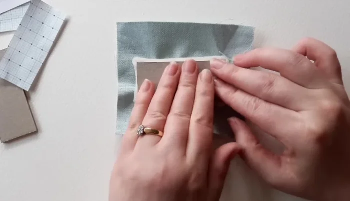 Cut 1cm strip of lightweight card, cover in fabric, and glue around cushion edges.