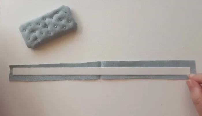 Cut 1cm strip of lightweight card, cover in fabric, and glue around cushion edges.