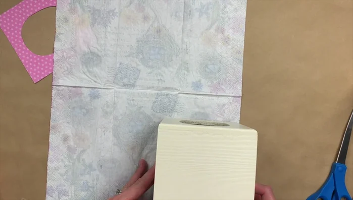 Cut out scrapbook paper to fit the top of the box. Apply Mod Podge and attach the paper. 