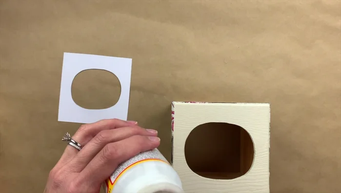 Cut out scrapbook paper to fit the top of the box. Apply Mod Podge and attach the paper. 