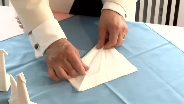 Fold the top section down to create the back of the swan. Use the initial crease line as a guide.