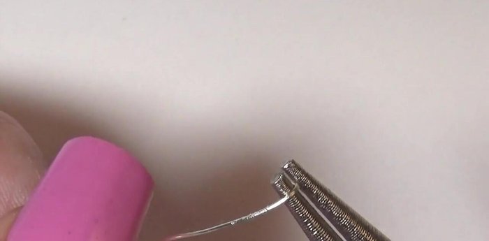 Make a ring. Flatten wire with pliers, shape with round nose pliers. Conceal the seam with glue and a rhinestone or glitter.