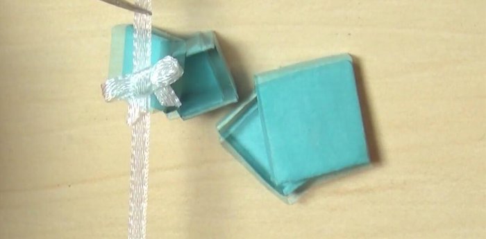 Make a bow from white ribbon and glue it to the outside of one box. Line the inside with black fabric.