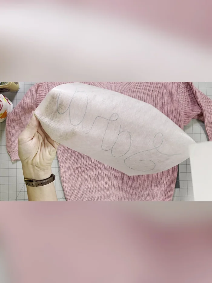 Peel the paper backing off the stabilizer. Center and firmly adhere it to the sweater.