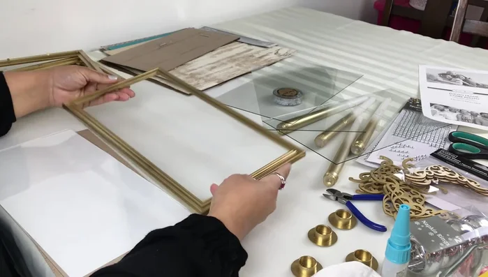 Assemble the base: Remove tabs from three frames. Attach the bottom frame (tabs removed) to the cardboard and paper, then insert the glass.