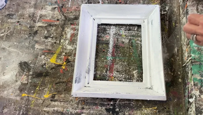 Gently scrape away some of the white paint in areas where wax remains, for further distressing.