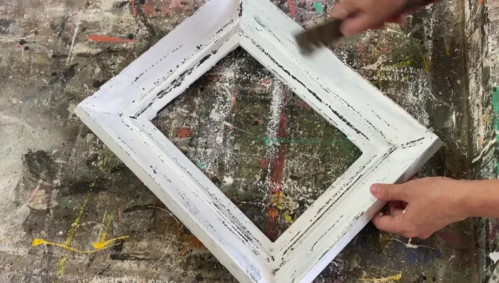 Gently scrape away some of the white paint in areas where wax remains, for further distressing.