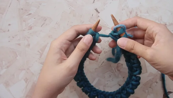 Remove the stitch marker from the left needle and place it on the right needle. Continue knitting.